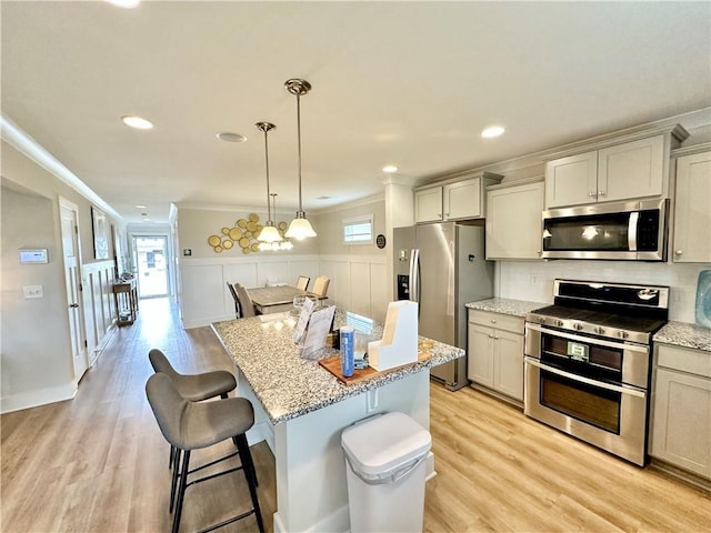 448 Seaborn Cir, Pendleton, SC 29670 - kitchen with appliances with stainless steel finishes, crown molding, a kitchen breakfast bar, light stone counters, and light wood-style flooring