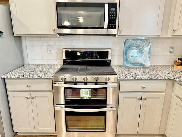 448 Seaborn Cir, Pendleton, SC 29670 - kitchen with appliances with stainless steel finishes, decorative backsplash, light stone counters, and white cabinetry