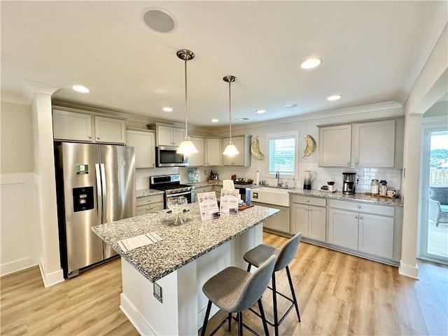 448 Seaborn Cir, Pendleton, SC 29670 - kitchen with appliances with stainless steel finishes, a center island, crown molding, backsplash, and a kitchen breakfast bar