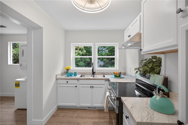 1103 Scott Dr, Anderson, SC 29625 - kitchen with stainless steel electric stove, under cabinet range hood, light wood-type flooring, and white cabinetry