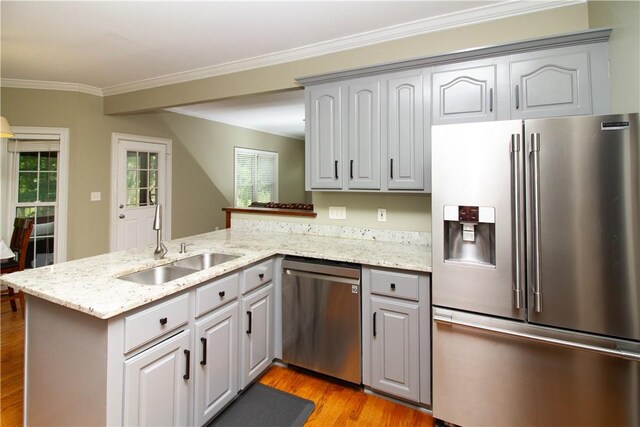 104 Tinsley Dr, Anderson, SC 29621 - kitchen with appliances with stainless steel finishes, a sink, a peninsula, light wood-style floors, and ornamental molding