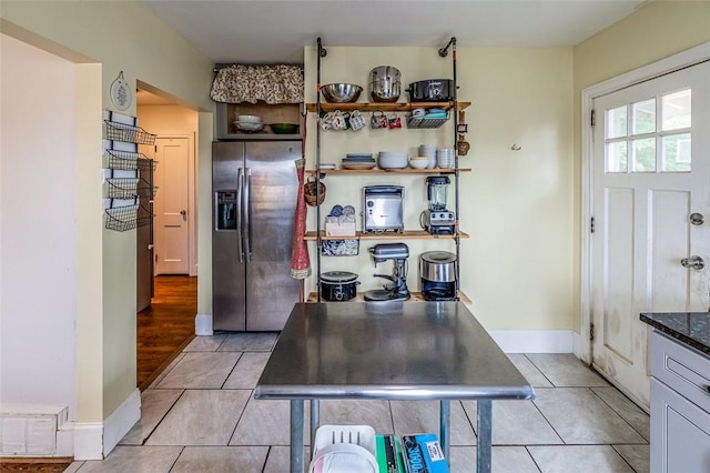 6913 White Horse Rd, Greenville, SC 29611 - kitchen with stainless steel fridge, light tile patterned floors, baseboards, and dark stone countertops