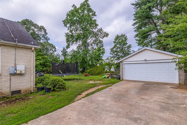 6913 White Horse Rd, Greenville, SC 29611 - view of green lawn featuring a trampoline, a detached garage, and an outbuilding