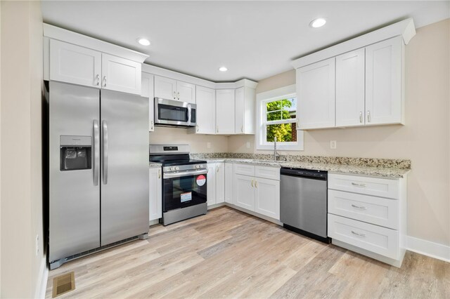 1205 W Franklin St, Anderson, SC 29624 - kitchen featuring appliances with stainless steel finishes, a sink, light wood-style floors, white cabinets, and recessed lighting