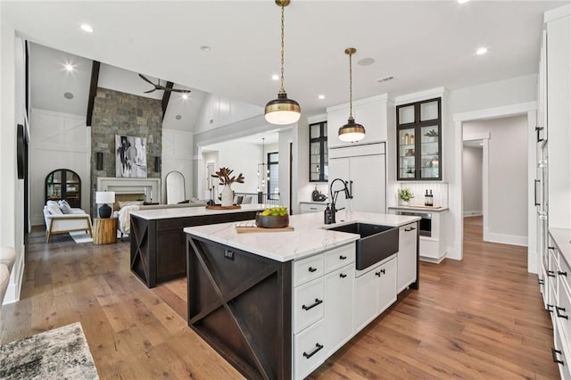 221 Hermitage Dr, Six Mile, SC 29682 - kitchen with an island with sink, a sink, wood finished floors, glass insert cabinets, and lofted ceiling