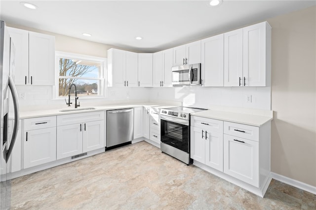 509 Old Clemson Hwy, Seneca, SC 29672 - kitchen featuring stainless steel appliances, a sink, decorative backsplash, white cabinetry, and light countertops
