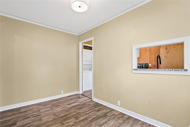 710 Greenville St, Pendleton, SC 29670 - unfurnished room with stacked washing machine and dryer, ornamental molding, wood finished floors, and baseboards