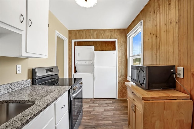 710 Greenville St, Pendleton, SC 29670 - kitchen with stacked washing machine and dryer, freestanding refrigerator, stainless steel electric range, black microwave, and wood counters