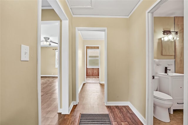 710 Greenville St, Pendleton, SC 29670 - hallway with wood finished floors, a sink, crown molding, baseboards, and attic access