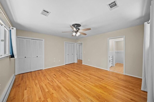 333 Woodland Way, Clemson, SC 29631 - unfurnished bedroom with a baseboard heating unit, light wood-style flooring, two closets, and a ceiling fan