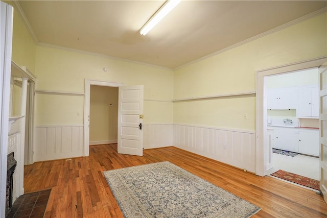 206 W N 1st St, Seneca, SC 29678 - spare room featuring a wainscoted wall, wood finished floors, crown molding, and a fireplace with flush hearth
