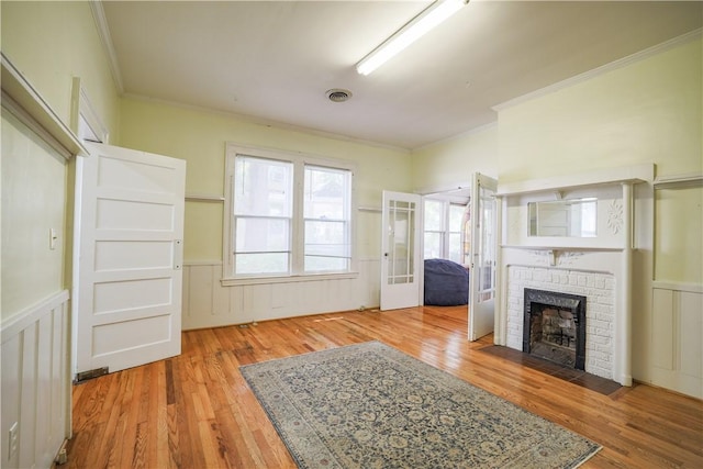 206 W N 1st St, Seneca, SC 29678 - unfurnished living room with crown molding, wood finished floors, wainscoting, and a brick fireplace