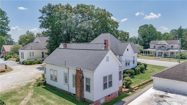 206 W N 1st St, Seneca, SC 29678 - view of side of home with roof with shingles, dirt driveway, a lawn, and a residential view