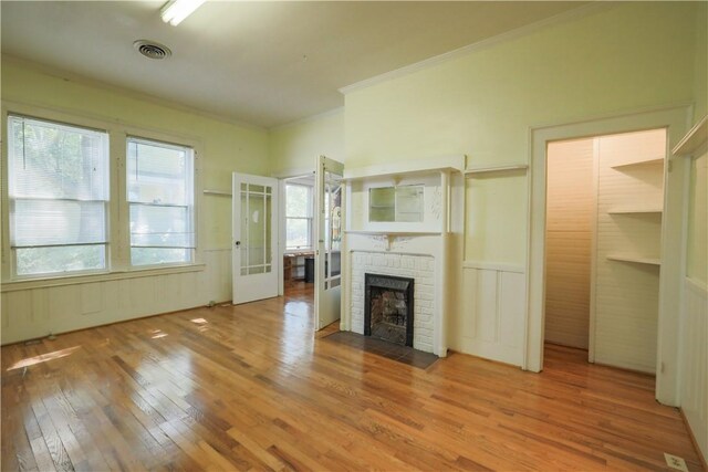 206 W N 1st St, Seneca, SC 29678 - unfurnished living room featuring hardwood / wood-style flooring, ornamental molding, a brick fireplace, and a wainscoted wall
