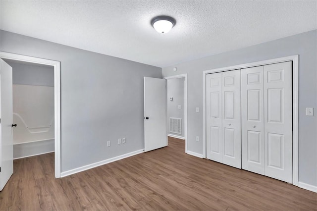 301 Wardlaw St, Anderson, SC 29624 - unfurnished bedroom featuring wood finished floors, a textured ceiling, a closet, and baseboards