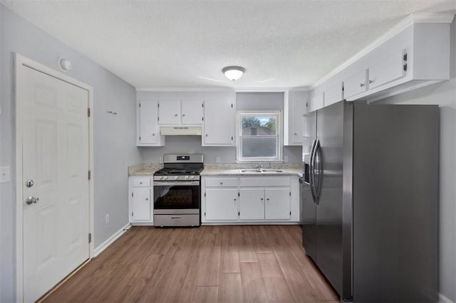 301 Wardlaw St, Anderson, SC 29624 - kitchen featuring appliances with stainless steel finishes, under cabinet range hood, white cabinets, light countertops, and a textured ceiling