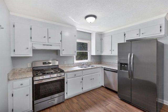 301 Wardlaw St, Anderson, SC 29624 - kitchen featuring appliances with stainless steel finishes, under cabinet range hood, a sink, a textured ceiling, and white cabinets