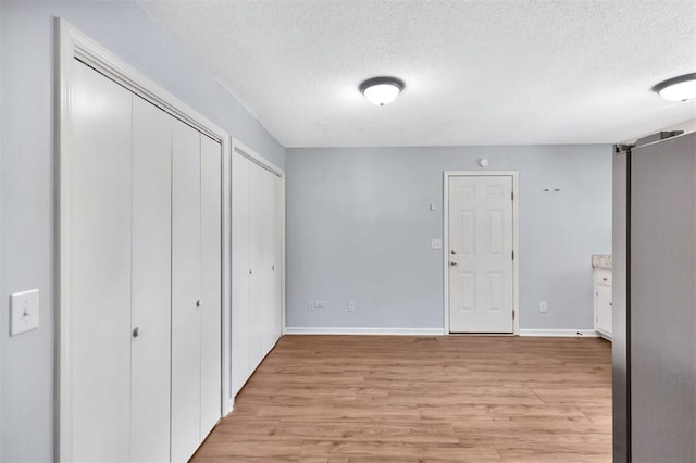 301 Wardlaw St, Anderson, SC 29624 - unfurnished bedroom with a textured ceiling, two closets, light wood-style floors, and baseboards