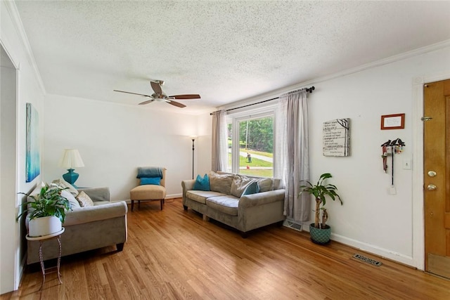 125 Brookwood Rd, Seneca, SC 29678 - living room featuring a textured ceiling, ornamental molding, light wood-style floors, a ceiling fan, and baseboards