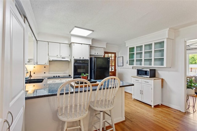 125 Brookwood Rd, Seneca, SC 29678 - kitchen with black appliances, a sink, a peninsula, light wood-style flooring, and dark stone countertops