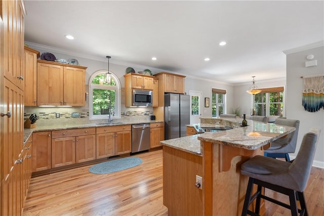 606 Lighthouse Ct, Seneca, SC 29672 - kitchen featuring appliances with stainless steel finishes, a sink, light wood-style flooring, ornamental molding, and plenty of natural light