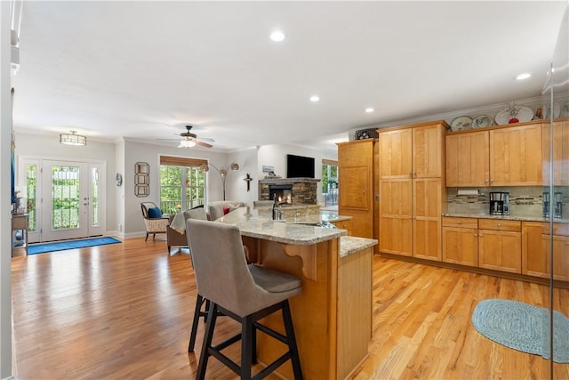 606 Lighthouse Ct, Seneca, SC 29672 - kitchen featuring open floor plan, backsplash, light wood finished floors, a stone fireplace, and recessed lighting