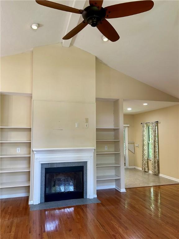 105 Eagle Ct, Westminster, SC 29693 - unfurnished living room with wood-type flooring, a ceiling fan, a tile fireplace, baseboards, and built in features