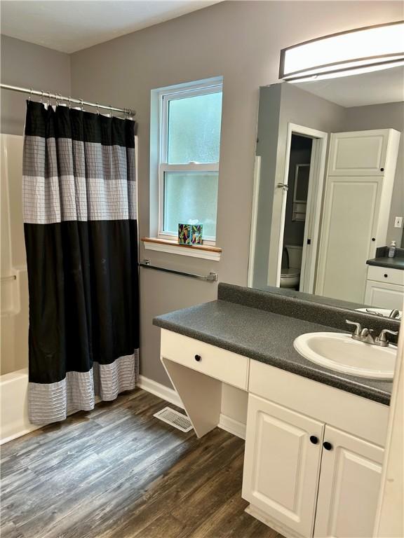 105 Eagle Ct, Westminster, SC 29693 - bathroom featuring vanity, wood finished floors, toilet, baseboards, and shower / bath combination with curtain