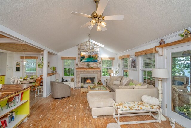 79 Blue Heron Cv, Abbeville, SC 29620 - living area featuring a ceiling fan, wood finished floors, a textured ceiling, vaulted ceiling, and a fireplace