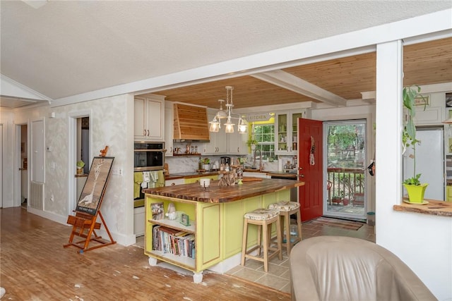 79 Blue Heron Cv, Abbeville, SC 29620 - kitchen with wooden counters, open shelves, custom exhaust hood, a kitchen breakfast bar, and a kitchen island