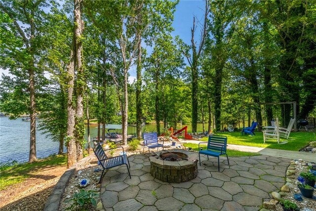 79 Blue Heron Cv, Abbeville, SC 29620 - view of patio with an outdoor fire pit, a water view, view of wooded area, and a playground
