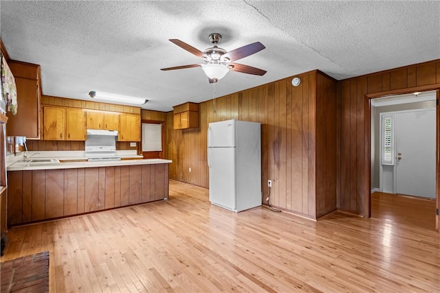 2909 Olive St, Anderson, SC 29625 - kitchen featuring white appliances, a peninsula, under cabinet range hood, brown cabinetry, and ceiling fan