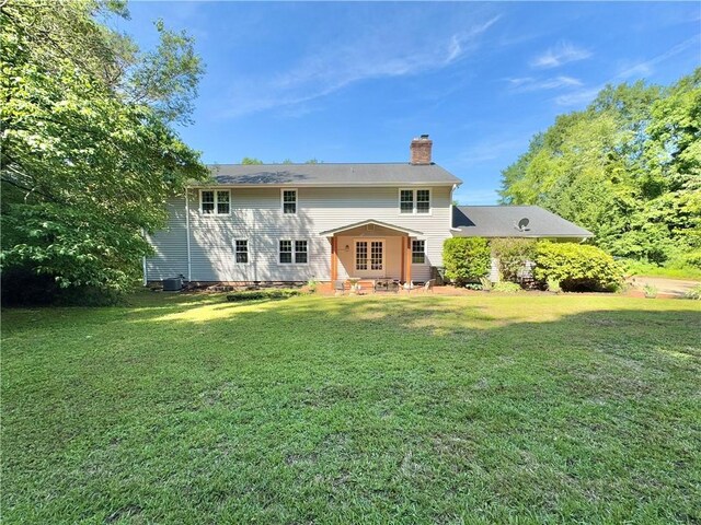 102 Buckingham Ct, Easley, SC 29640 - rear view of house featuring a chimney, a lawn, and central AC unit