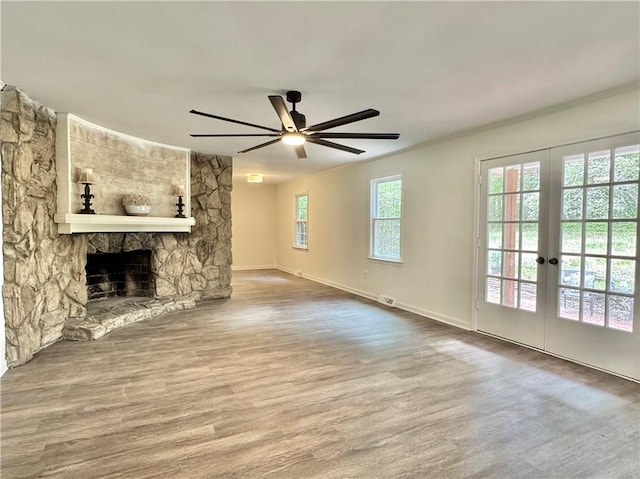 102 Buckingham Ct, Easley, SC 29640 - unfurnished living room with ceiling fan, wood finished floors, a stone fireplace, ornamental molding, and french doors