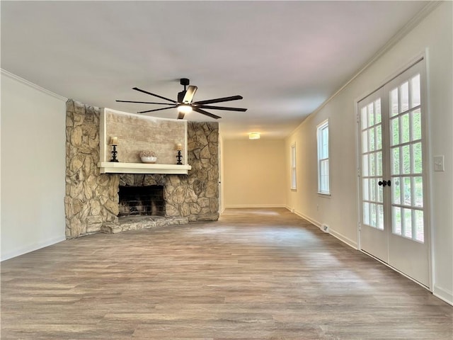 102 Buckingham Ct, Easley, SC 29640 - unfurnished living room with crown molding, wood finished floors, a stone fireplace, ceiling fan, and baseboards