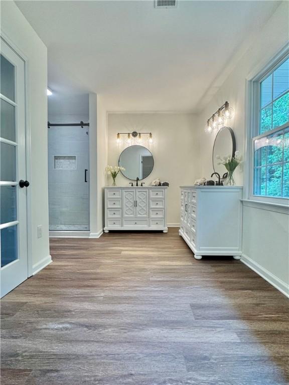 102 Buckingham Ct, Easley, SC 29640 - bathroom featuring wood finished floors, two vanities, a shower stall, and baseboards