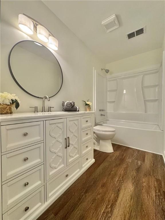 102 Buckingham Ct, Easley, SC 29640 - bathroom featuring toilet, vanity, wood finished floors, and washtub / shower combination