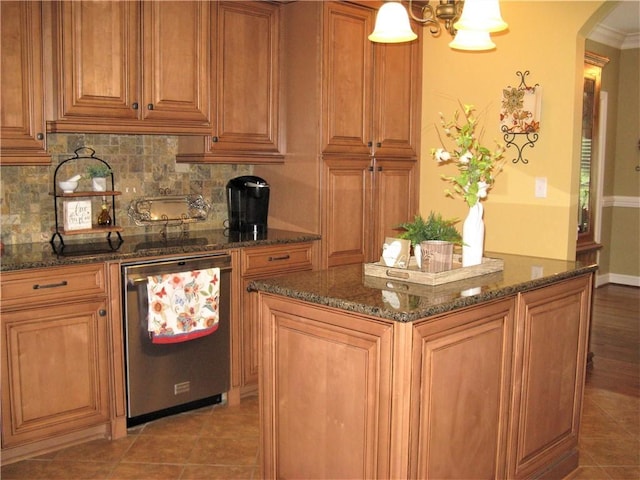 307 Holly Ridge Dr, Anderson, SC 29621 - kitchen featuring arched walkways, tasteful backsplash, dark stone countertops, and brown cabinetry