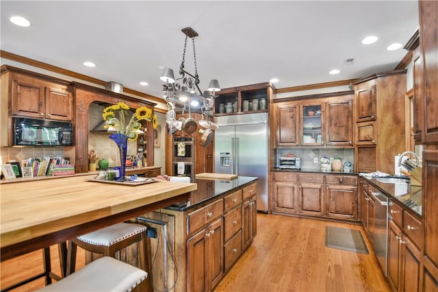 405 Windcrest Ct, Salem, SC 29676 - kitchen with stainless steel appliances, a breakfast bar, decorative backsplash, light wood-style floors, and crown molding