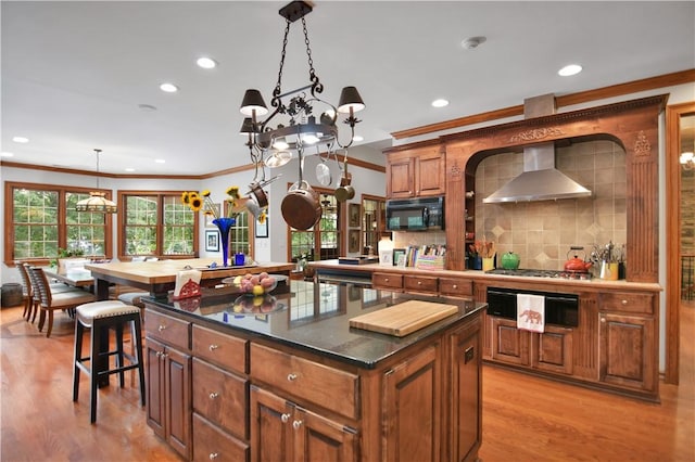 405 Windcrest Ct, Salem, SC 29676 - kitchen featuring wall chimney exhaust hood, black microwave, a center island, brown cabinets, and tasteful backsplash