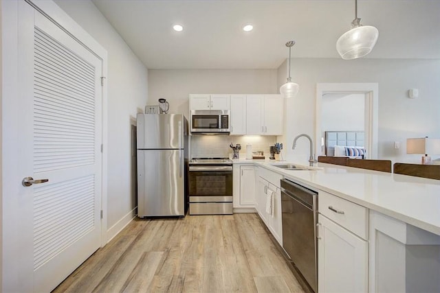 13500 Clemson Blvd Unit 2410, Seneca, SC 29678 - kitchen with stainless steel appliances, light wood finished floors, backsplash, white cabinets, and pendant lighting