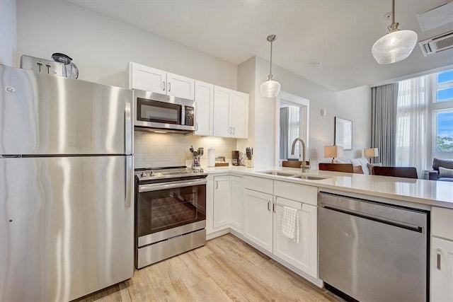 13500 Clemson Blvd Unit 2410, Seneca, SC 29678 - kitchen with appliances with stainless steel finishes, light wood-type flooring, light countertops, backsplash, and white cabinetry
