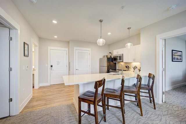 13500 Clemson Blvd Unit 2410, Seneca, SC 29678 - kitchen with stainless steel appliances, a breakfast bar area, a peninsula, white cabinetry, and recessed lighting