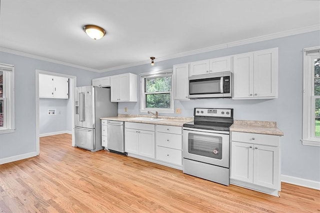 440 Cooley Bridge Rd, Pelzer, SC 29669 - kitchen featuring appliances with stainless steel finishes, light countertops, light wood-style floors, white cabinetry, and crown molding