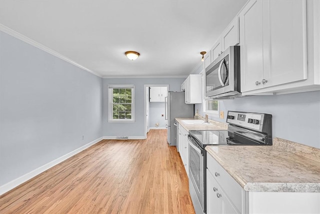 440 Cooley Bridge Rd, Pelzer, SC 29669 - kitchen with stainless steel appliances, crown molding, white cabinetry, light wood-style flooring, and light countertops