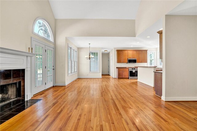 10 Laurelcrest Ln, Travelers Rest, SC 29690 - unfurnished living room with light wood-type flooring, a tile fireplace, healthy amount of natural light, and a high ceiling