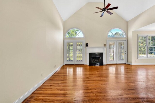 10 Laurelcrest Ln, Travelers Rest, SC 29690 - unfurnished living room with wood finished floors, plenty of natural light, a ceiling fan, high vaulted ceiling, and a fireplace with flush hearth