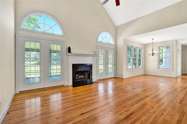10 Laurelcrest Ln, Travelers Rest, SC 29690 - unfurnished living room featuring a chandelier, wood finished floors, high vaulted ceiling, a tiled fireplace, and ceiling fan
