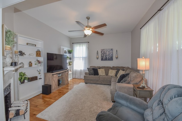 102 Langely St, Abbeville, SC 29620 - living area featuring a fireplace with raised hearth, ceiling fan, and light wood-style floors