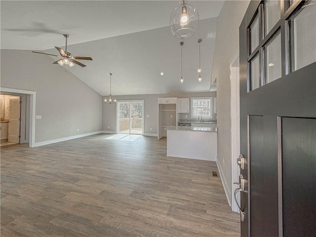 325 Code Cir, Seneca, SC 29678 - unfurnished living room featuring a ceiling fan, high vaulted ceiling, light wood finished floors, and a chandelier